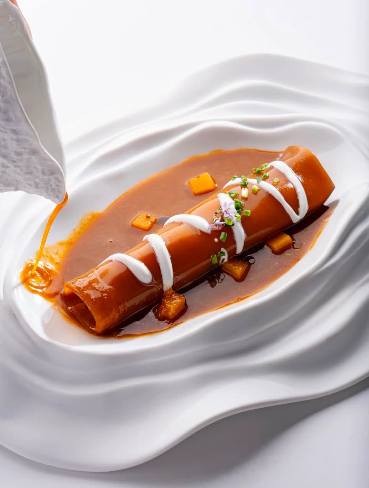 Presentación minimalista de aceitunas verdes y negras con ramas de olivo sobre bandeja blanca en Restaurant La Llotja, España, cocina mediterránea